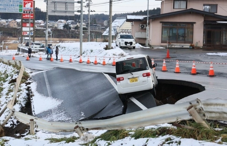 지난해 12월 9일 일본 동북부 아오모리현 도호쿠마치에서 도로가 붕괴된 가장자리에 차량 한 대가 걸쳐 있다. AFP 연합뉴스