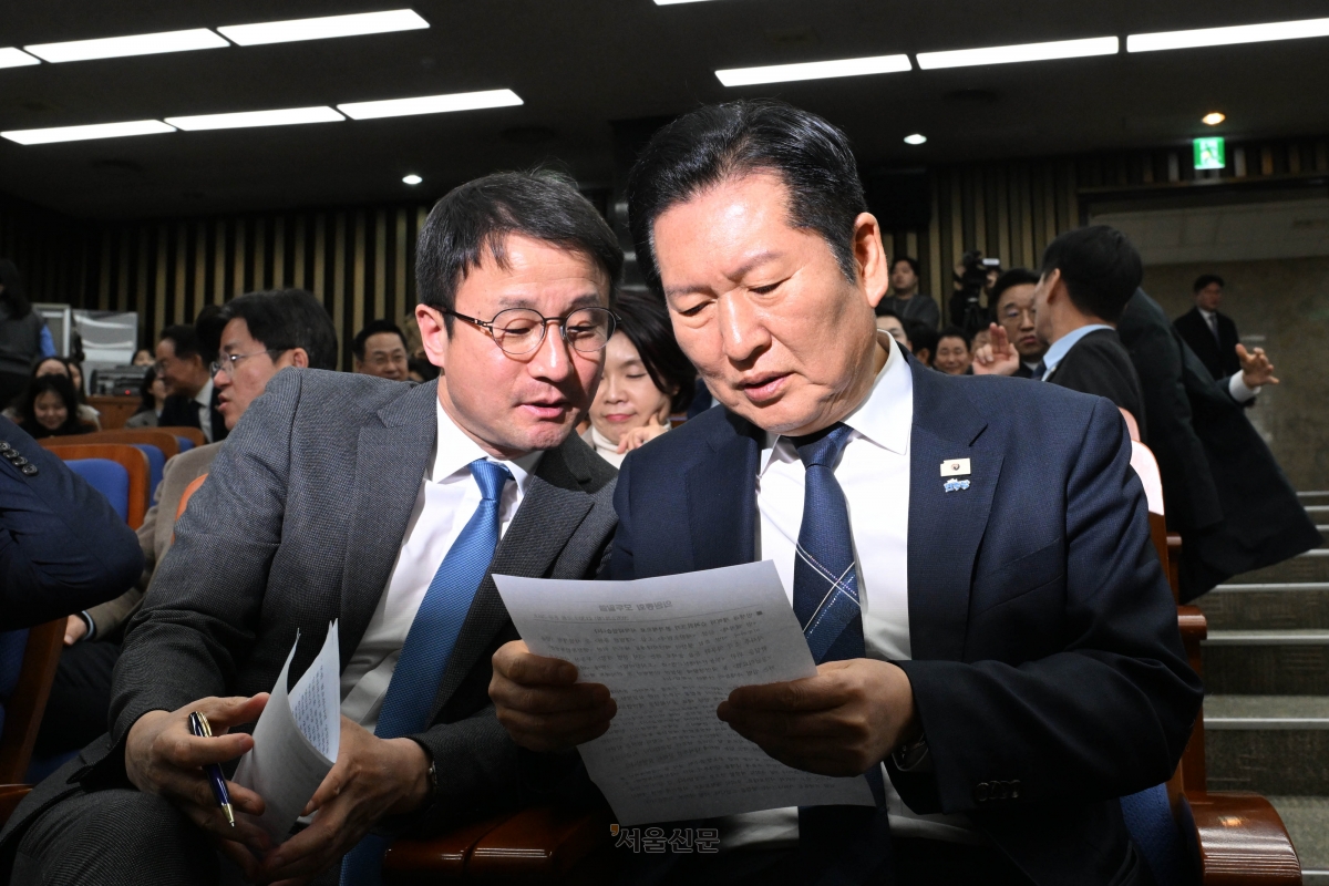 더불어민주당 정청래(오른쪽) 대표와 한병도 원내대표가 24일 국회에서 열린 의원총회에서 회의 자료를 함께 보며 이야기를 나누고 있다. 홍윤기 기자