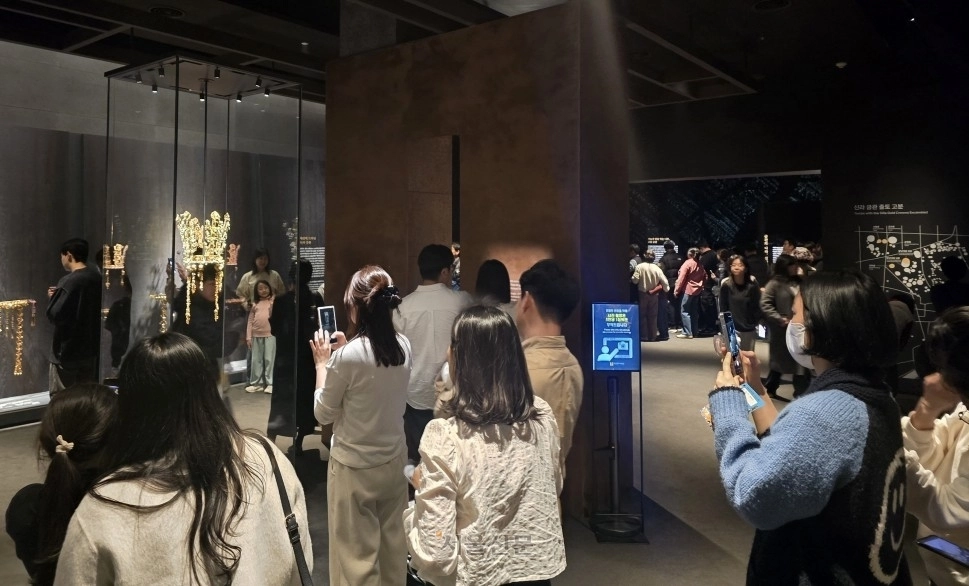 ‘신라 금관, 권력과 위신’ 전시 마지막 날이었던 지난 22일 경북 경주시 국립경주박물관을 찾은 관람객들이 황남대총 금관과 함께 사진을 찍기 위해 길게 줄지어 서 있다.
