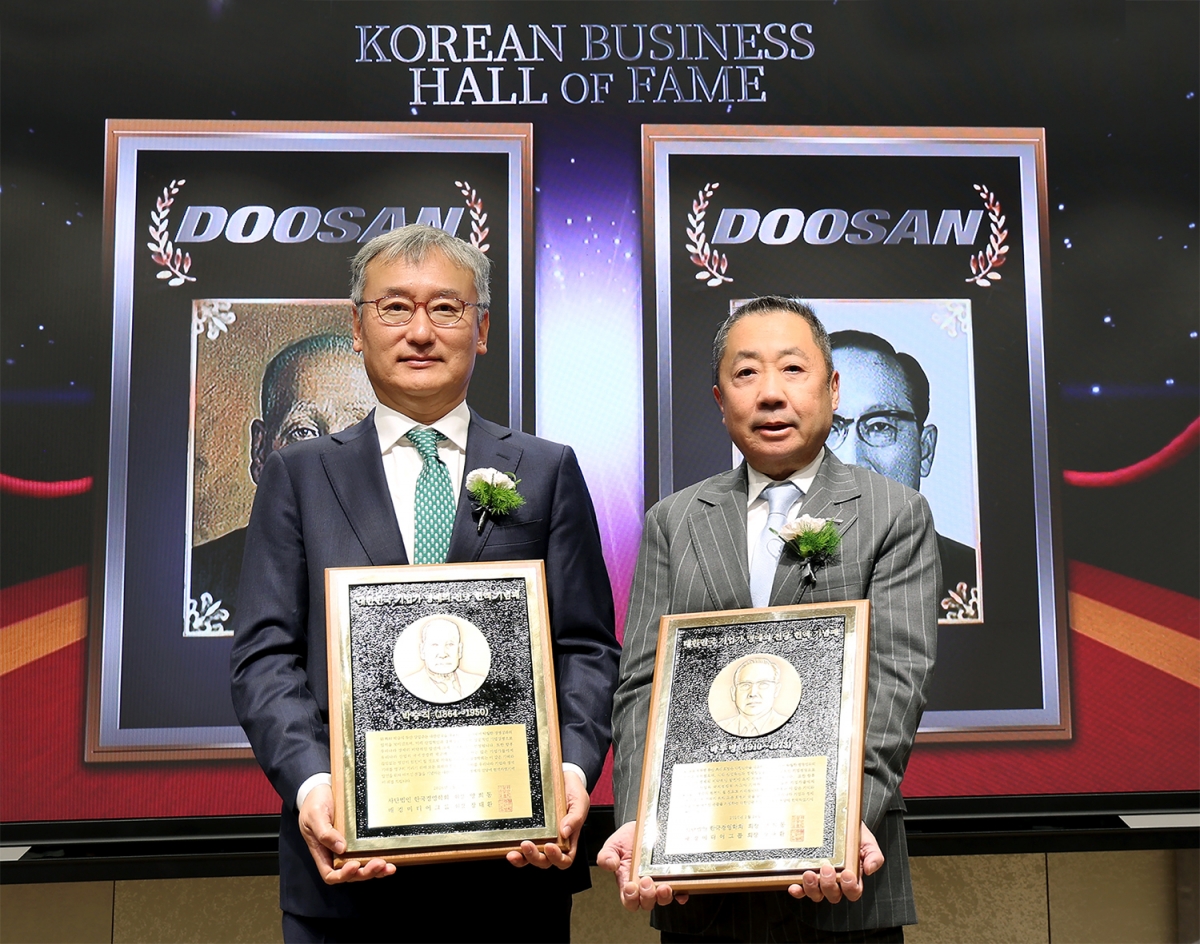 박정원(오른쪽) 두산그룹 회장이 24일 서울 서대문구 이화여대 경영대학 60주년 기념홀에서 열린 ‘대한민국 기업가 명예의 전당’ 헌액식에서 헌액 기념패를 든 채 양희동 한국경영학회 회장과 기념촬영을 하고 있다. 두산 제공