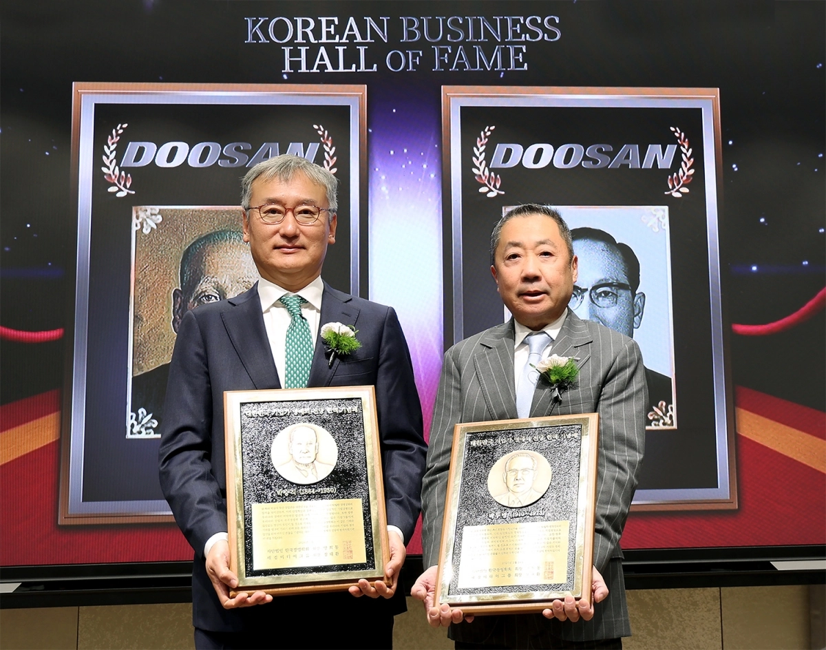 박정원(오른쪽) 두산그룹 회장이 24일 서울 서대문구 이화여대 경영대학 60주년 기념홀에서 열린 ‘대한민국 기업가 명예의 전당’ 헌액식에서 헌액 기념패를 든 채 양희동 한국경영학회 회장과 기념촬영을 하고 있다. 두산 제공