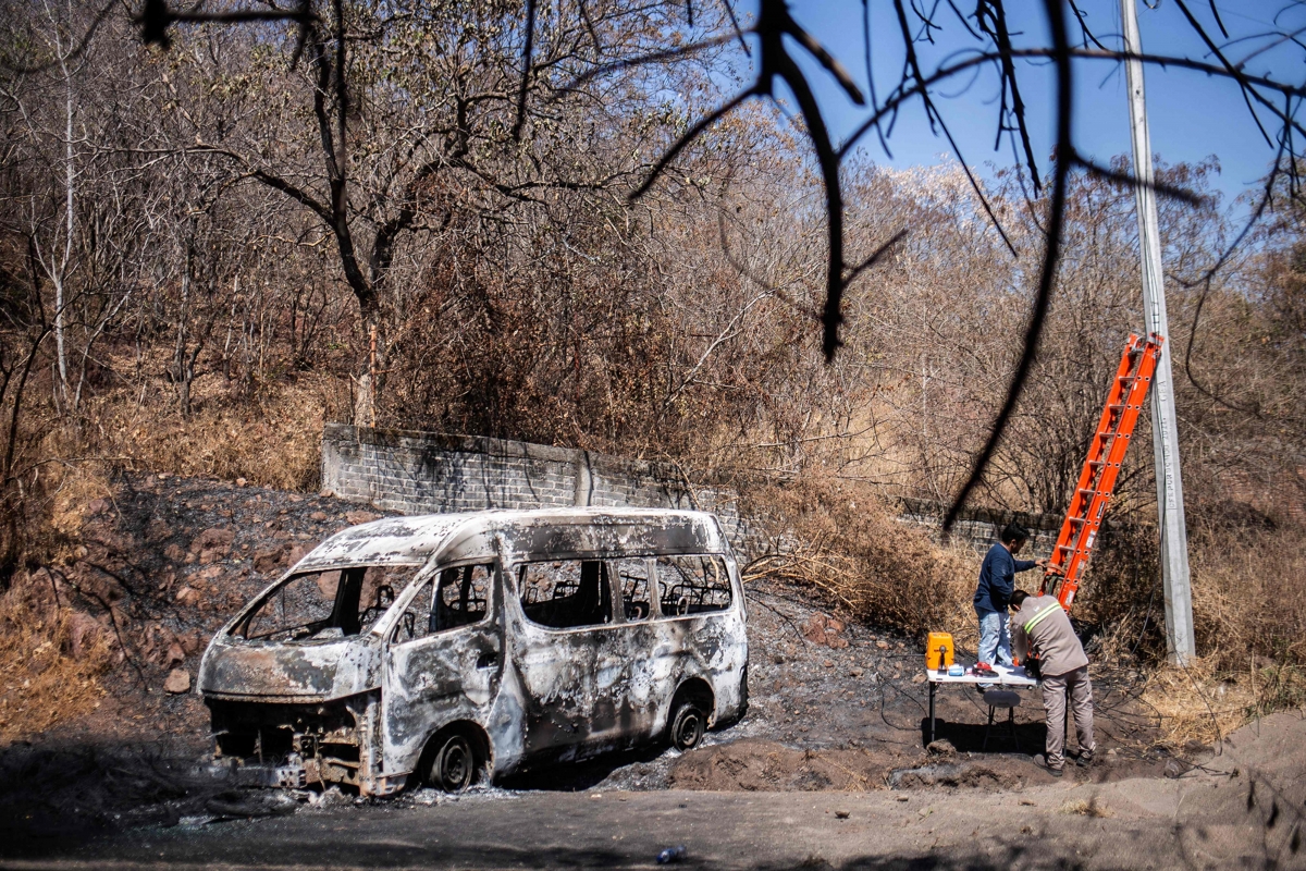 국제축구연맹(FIFA)이 2026북중미월드컵이 치러질 멕시코 할리스코주 치안문제에 대해 관심을 갖고 면밀히 지켜보고 있다고 밝혔다. 사진은 마약 카르텔 조직원들에 의해 불탄 자동차를 현지 주민이 바라보는 모습. 티에라 칼리엔테 AFP 연합뉴스