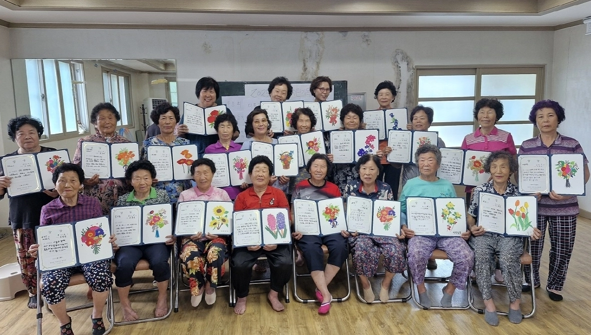황전 비촌마을 주민들이 ‘마을자원기록’ 프로그램의 일환으로 마을 달력에 삽입될 그림을 완성한 뒤 단체 기념사진을 촬영하고 있다.