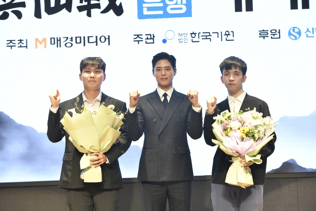 박정환(왼쪽) 9단과 왕싱하오(오른쪽) 9단이 25일 서울 중구 신한은행 본점에서 열린 제1회 신한은행 세계 기선전에 앞서 배우 박보검으로 꽃다발을 전달받은 뒤 기념사진을 찍고 있다. 한국기원 제공