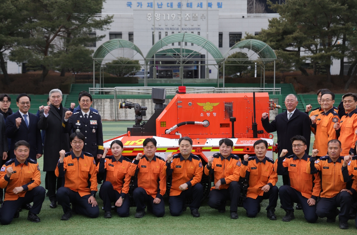 이용배 현대로템 사장, 성 김 현대자동차그룹 사장, 김승룡 소방청장 직무대행, 정의선 현대차그룹 회장(뒷줄 왼쪽부터)이 지난 24일 경기 남양주시 수도권119특수구조대에서 열린 현대차그룹의 소방청 무인소방로봇 기증식에서 소방관들과 기념촬영을 하고 있다. 현대차그룹 제공