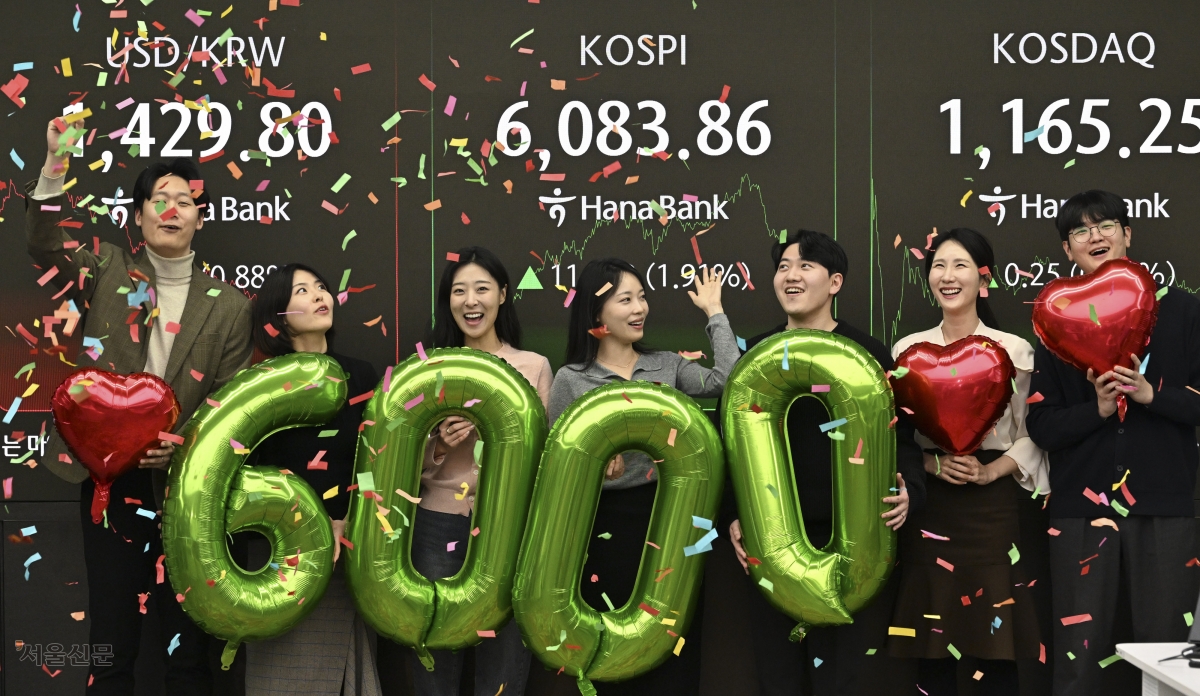 코스피가 사상 처음으로 6000을 돌파한 25일 서울 중구 하나은행 딜링룸에서 딜러들이 축하 세리머니를 하고 있다. 이날 코스피는 전 거래일 대비 1.91% 오른 6083.86에 거래를 마쳤다. 코스닥은 전 거래일 대비 0.02% 오른 1165.25에 장을 마감했다. 도준석 전문기자
