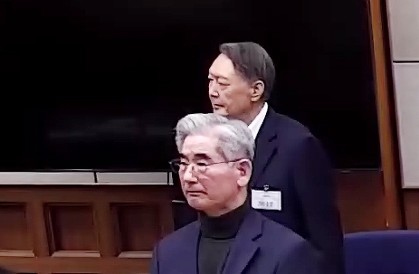 윤석열(위) 전 대통령이 19일 서울 서초구 서울중앙지방법원에서 열린 내란 우두머리 혐의 사건 1심 선고기일에서 지귀연 부장판사의 주문을 듣고 있다. 법원은 내란 우두머리 혐의로 기소된 윤 전 대통령에게 무기징역을 선고했다. 아래는 김용현 전 국방부 장관. 뉴시스