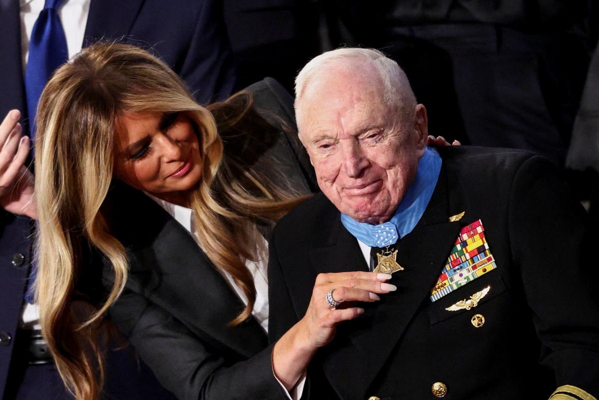 한국전쟁 영웅으로 ‘원조 탑건’이라 불리는 엘머 로이스 윌리엄스(오른쪽) 예비역 대령에게 24일(현지시간) 멜라니아 트럼프 여사가 미국 최고 무공훈장을 걸어 주고 있다. 워싱턴DC 로이터 연합뉴스