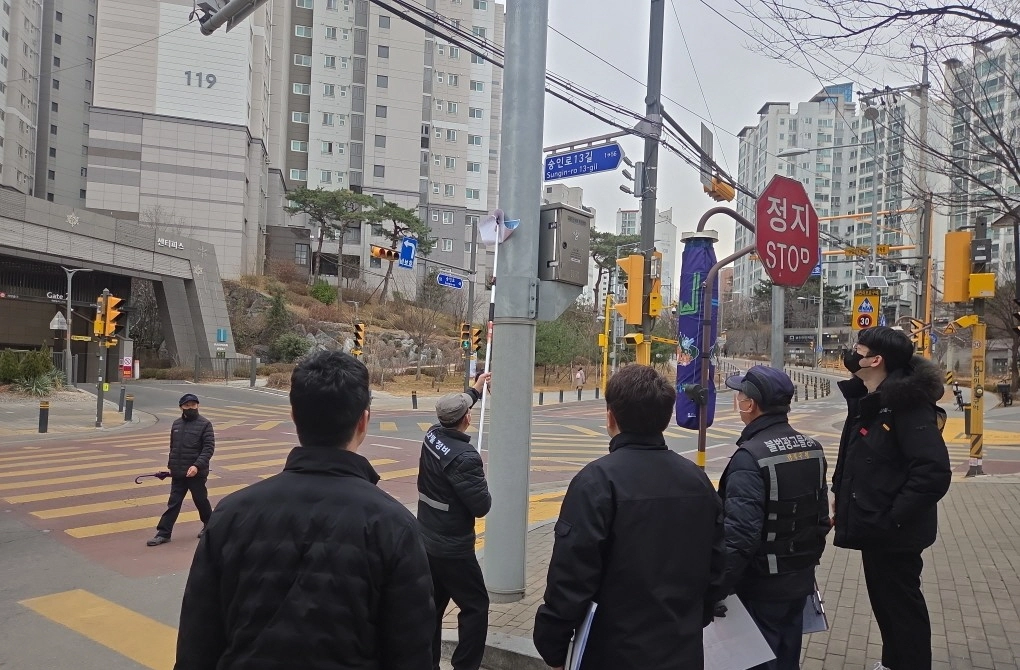 강북구청 직원 등으로 구성된 점검반과 강북경찰서 관계자들이 지난 24일 영훈초 앞 불법광고물을 정비하고 있다. 강북구 제공