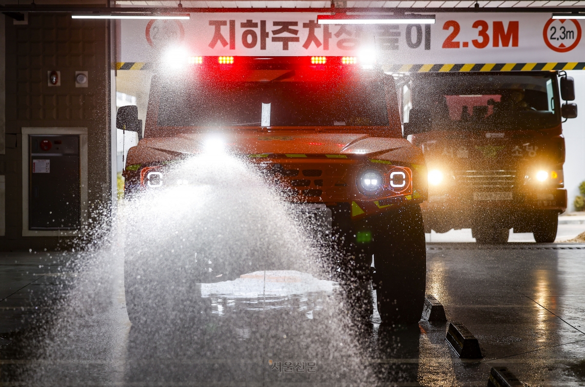 26일 서울 은평구 서울소방학교에서 열린 ‘미래형 재난대응 체계’ 공개 시연회에서 서울소방재난본부의 ‘저상형 소방차’(왼쪽)가 높이 2.3m의 지하주차장으로 진입한 후 주행하며 방수포를 쏘고 있다. 2026.2.26. 도준석 전문기자