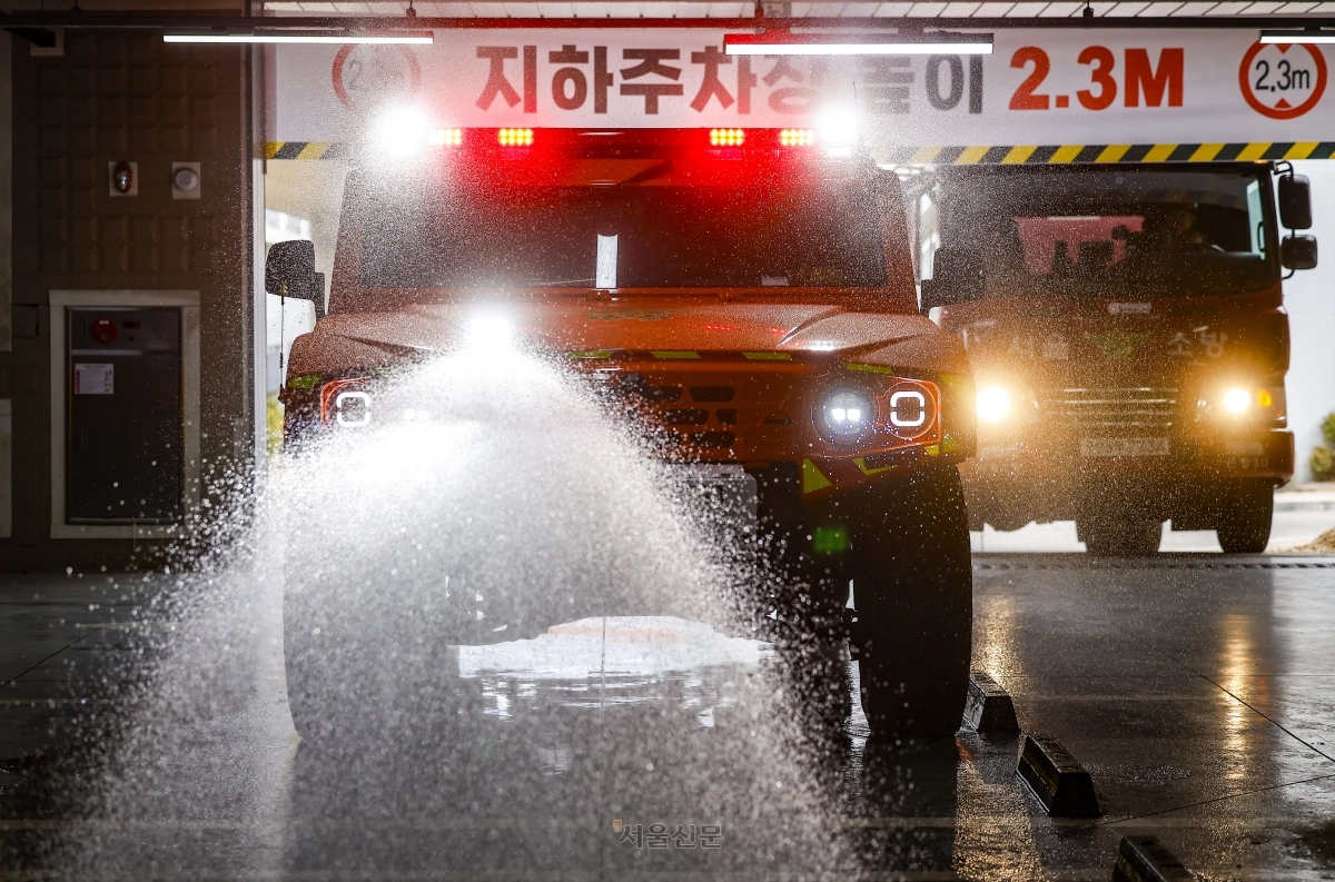26일 서울 은평구 서울소방학교에서 열린 ‘미래형 재난대응 체계’ 공개 시연회에서 서울소방재난본부의 ‘저상형 소방차’(왼쪽)가 높이 2.3m의 지하주차장으로 진입한 후 주행하며 방수포를 쏘고 있다. 2026.2.26. 도준석 전문기자