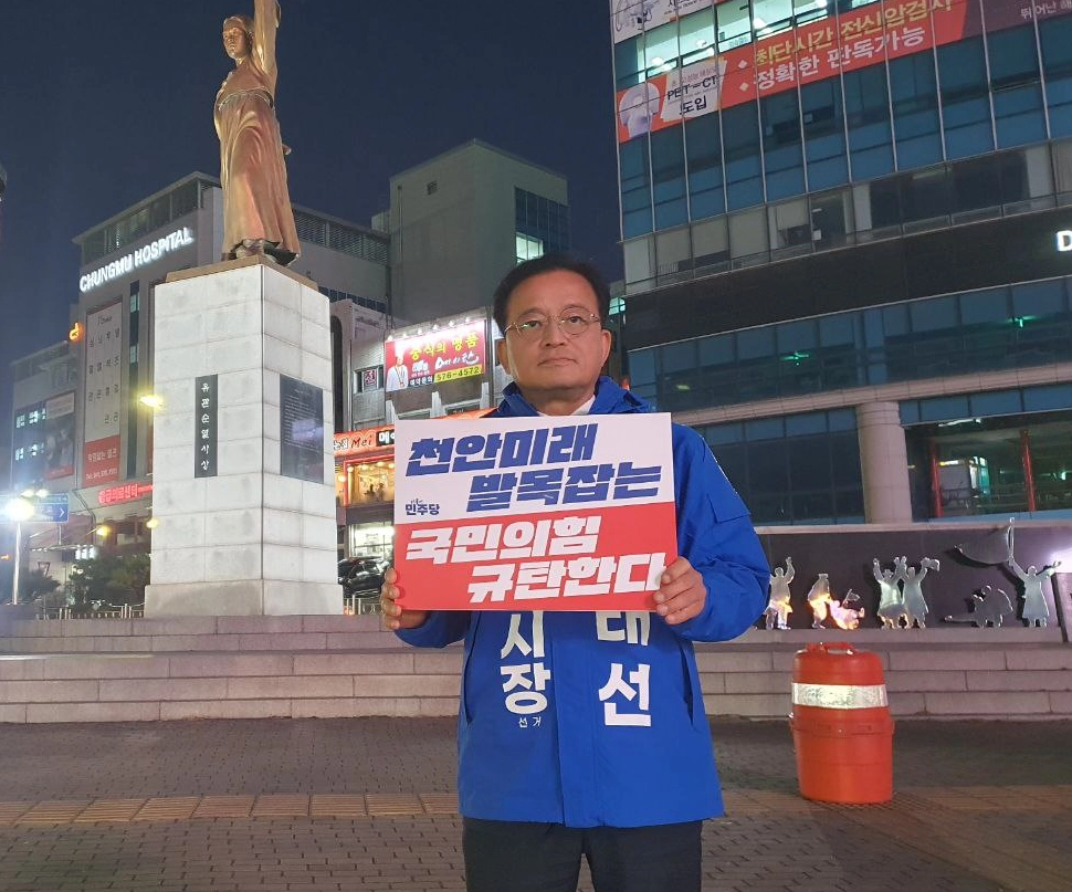 한태선 민주당 천안시장 예비후보가 예비후보 등록 후 일봉산사거리 일원에서 국민의힘 규탄 메시지가 담긴 피켓을 들고 있다. 한 예비후보 제공