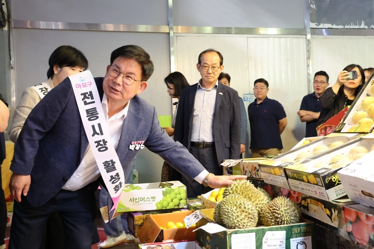 박강수(왼쪽) 서울 마포구청장이 전통시장 활성화를 위한 캠페인에 참여해 시장을 둘러보고 있다. 마포구 제공