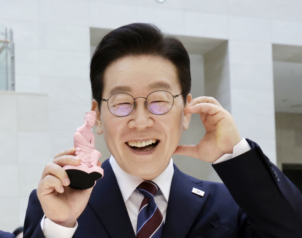 이재명 대통령이 26일 서울 용산구 국립중앙박물관에서 열린 특별전 ‘우리들의 이순신’을 관람한 뒤 상품관에서 기념품을 들고 포즈를 취하고 있다. 2026.2.26 연합뉴스