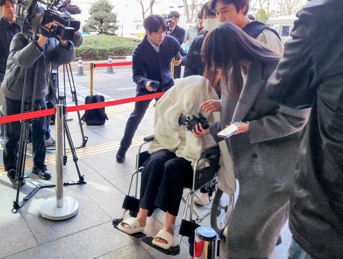 약에 취한 상태로 외제 SUV 차량을 몰고 반포대교를 달리다 한강 둔치로 추락한 운전자 A씨가 27일 서울 마포구 서부지방법원에서 열린 구속 전 피의자 심문(영장실질심사)에 옷으로 얼굴을 가리고 휠체어를 탄 채 출석하고 있다. 연합뉴스