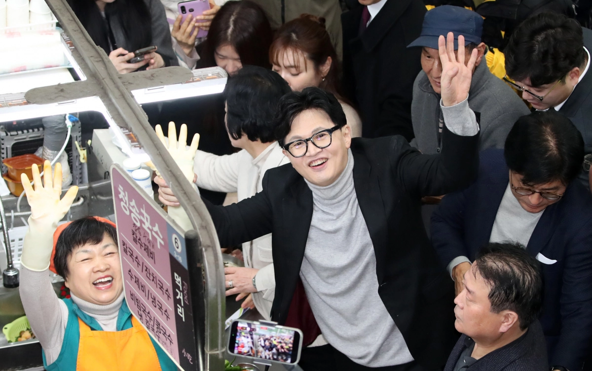 한동훈 전 국민의힘 대표가 27일 대구 중구 서문시장 국수골목을 찾아 상인과 함께 손을 흔들고 있다. 대구 뉴시스
