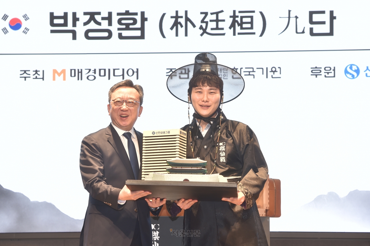 박정환(오른쪽) 9단이 27일 서울 중구 신한은행 본점 특설 대국장에서 열린 제1회 신한은행 세계 기선전 결승 3번기 최종국에서 중국의 왕싱하오 9단을 꺾고 우승한 뒤 열린 시상식에서 정상혁 신한은행장과 기념사진을 찍고 있다. 2026.2.27 한국기원 제공