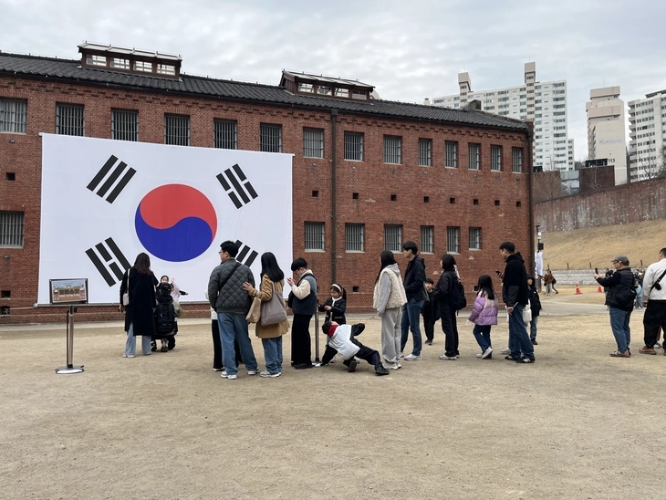 제107주년 3·1절인 1일 서울 서대문구 서대문형무소를 찾은 시민들이 대형 태극기 앞에서 기념촬영을 위해 줄을 서고 있다. 이날 서대문형무소의 방문객은 약 3만명으로 평소 방문객의 약 10배를 기록했다. 박다운 수습기자