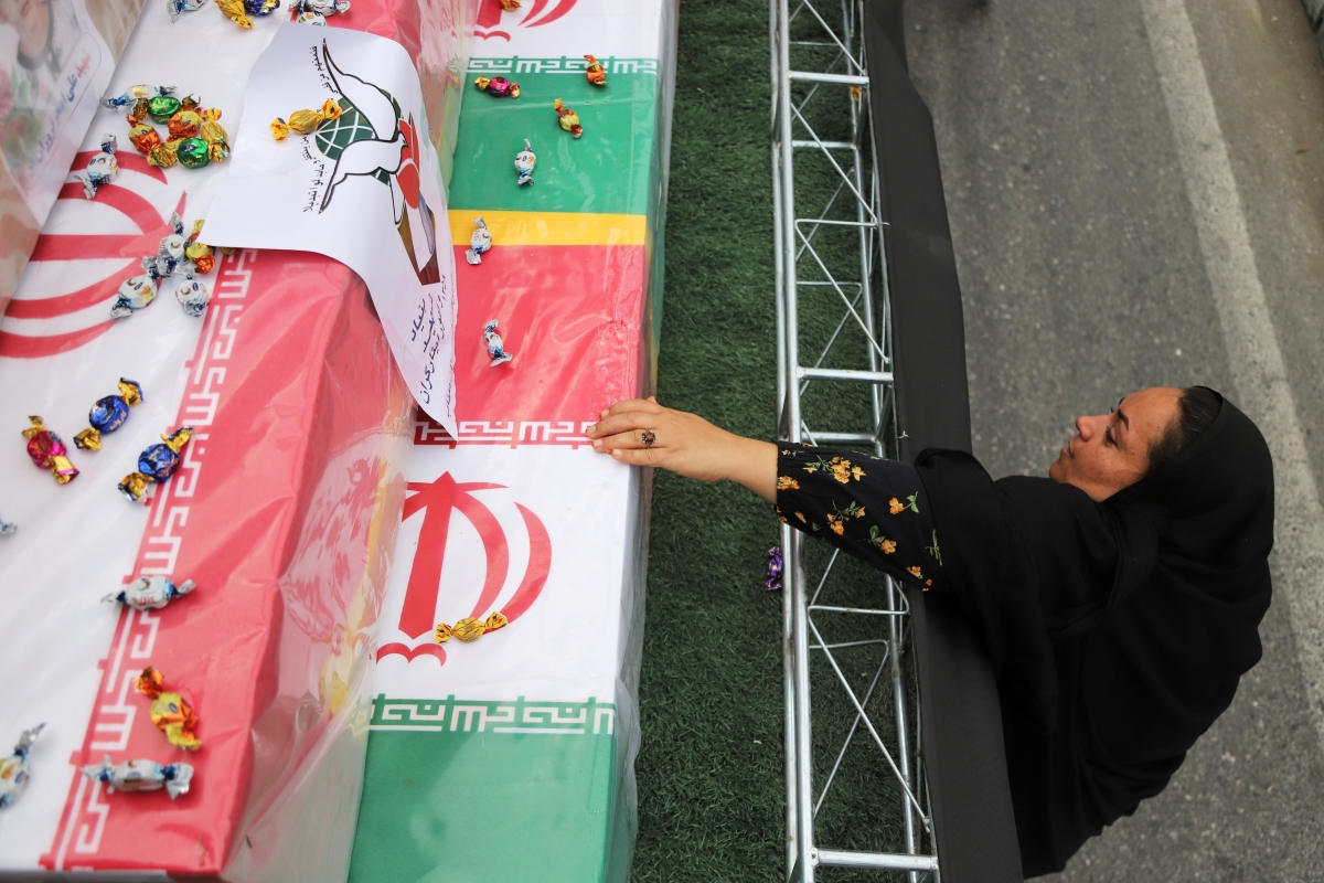 3일(현지시간) 이란 호르모즈간주 미나브시에서 지난달 28일 미국과 이스라엘 미사일 공습으로 사망한 샤자레 타이에베 여자초등학교 희생자 165명의 합동 장례식이 거행되고 있다. 사진은 한 여성이 자녀의 관에 손을 뻗고 있는 모습. 2026.3.3 미나브 AP 연합뉴스