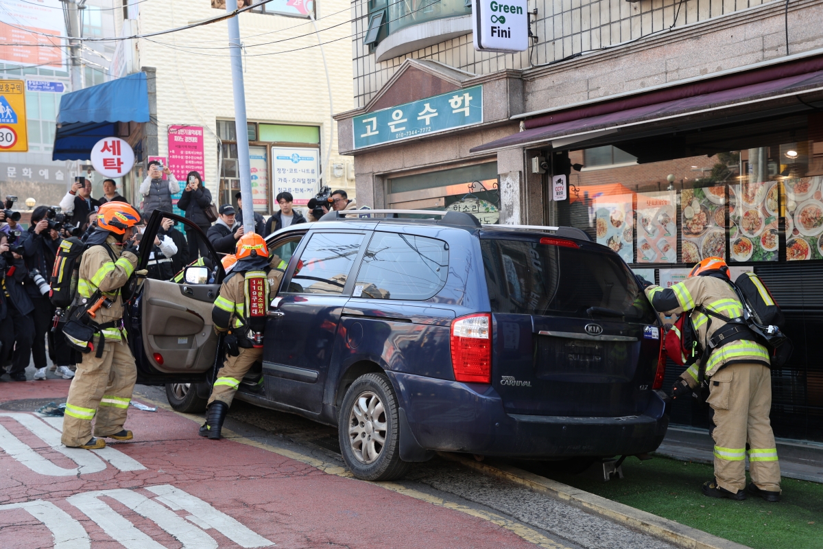 소방대원들이 4일 서울 서대문구 소방영웅길 일대에서 열린 ‘긴급출동 방해 차량 강제처분’ 공개 훈련에서 건물 출입구를 막아 인명대피 및 내부 진입을 방해하는 차량의 창문을 부수고 기어를 조작해 ‘강제이동’시키고 있다. 서울시 제공
