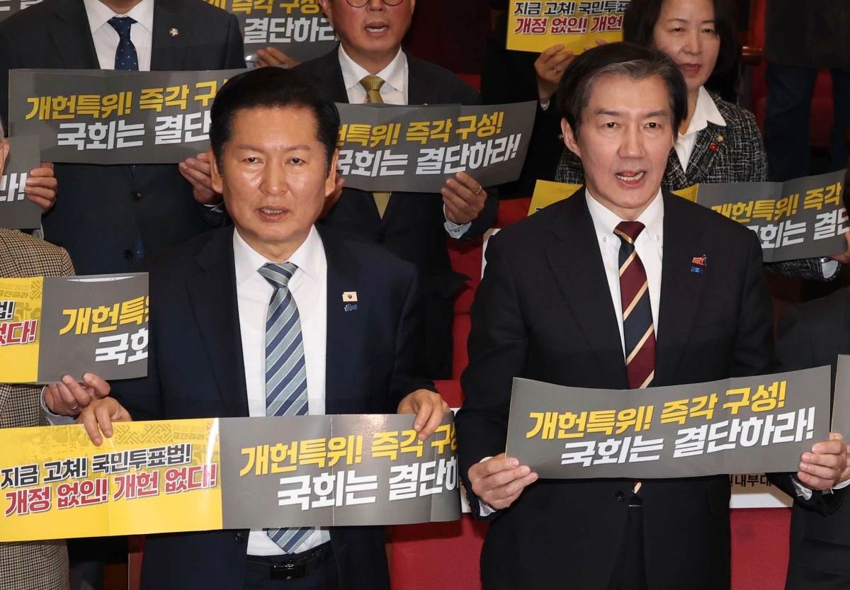 정청래(왼쪽) 더불어민주당 대표와 조국 조국혁신당 대표가 지난달 25일 국회 의원회관 대회의실에서 열린 5·18정신 헌법전문수록 개헌 촉구 국민결의대회에서 손피켓을 들고 구호를 외치고 있다. 뉴시스