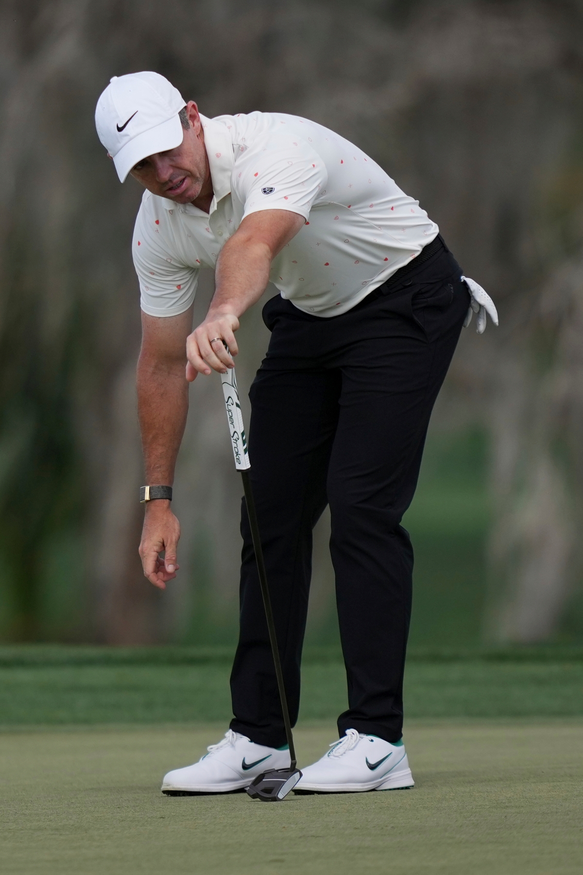 그린에서 굴러가는 볼을 자켜보는 매킬로이.