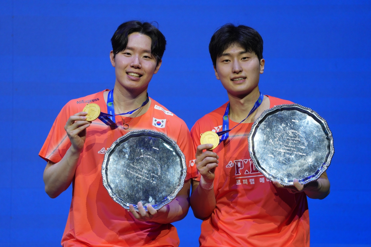 시상대에서 금메달과 전영오픈의 상징인 은색 쟁반 모양 트로피를 들어 보이는 서승재(왼쪽)와 김원호. AP 뉴시스