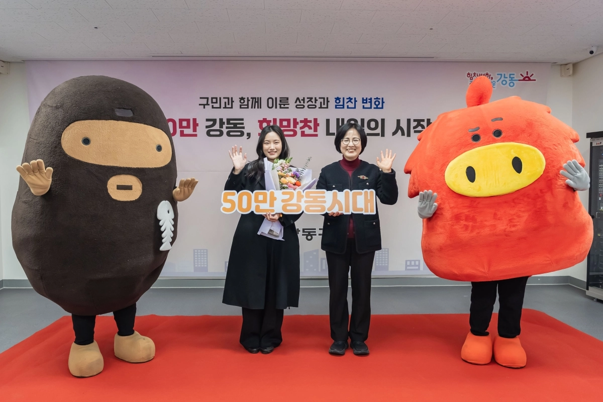 이수희(오른쪽) 서울 강동구청장이 지난 3일 천호2동 주민센터에서 열린 ‘50만 강동시대’ 기념행사에서 50만 번째 주민이 된 강노을씨, 구 마스코트인 움이(검은색), 코기(빨간색)와 함께 기념촬영을 하고 있다. 강동구 제공