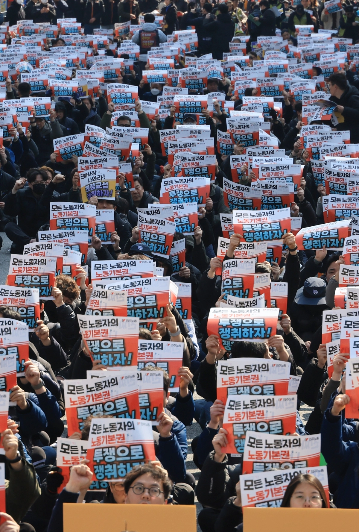 ‘노란봉투법’(노동조합 및 노동관계조정법 2·3조 개정 법률) 시행 첫날인 10일 서울 세종로에서 열린 민주노총 투쟁 선포대회에서 민주노총 조합원들이 손팻말을 들고 구호를 외치고 있다.  연합뉴스