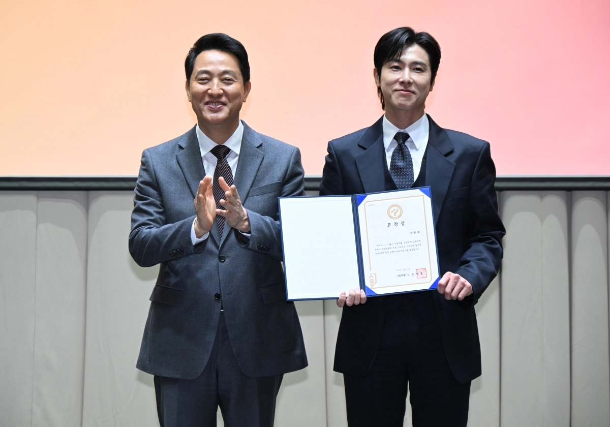 오세훈(왼쪽) 서울시장이 11일 서울시청에서 열린 ‘2026년 서울시 모범·유공납세자 표창 수여식’에서 가수 정윤호(오른쪽·동방신기 유노윤호)에게 표창을 한 뒤 기념촬영을 하고 있다. 서울시 제공