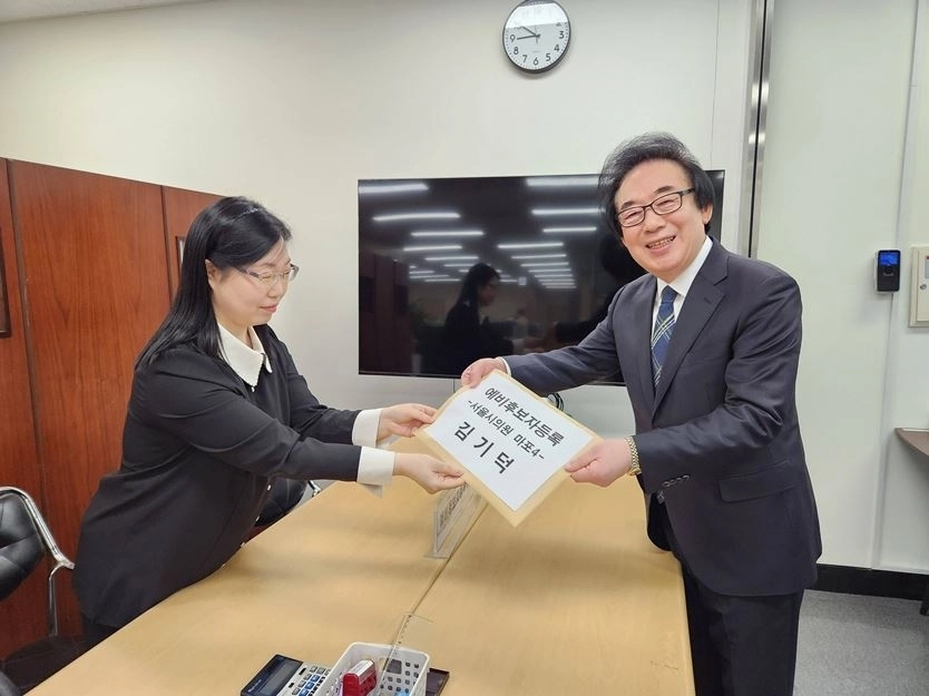 김기덕 서울시의원이 예비후보 등록 서류를 전달하고 있다.