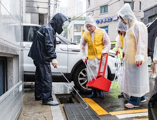 최호권(왼쪽 두 번째) 영등포구청장이 주민들과 빗물받이 청소를 하고 있다. 영등포구 제공