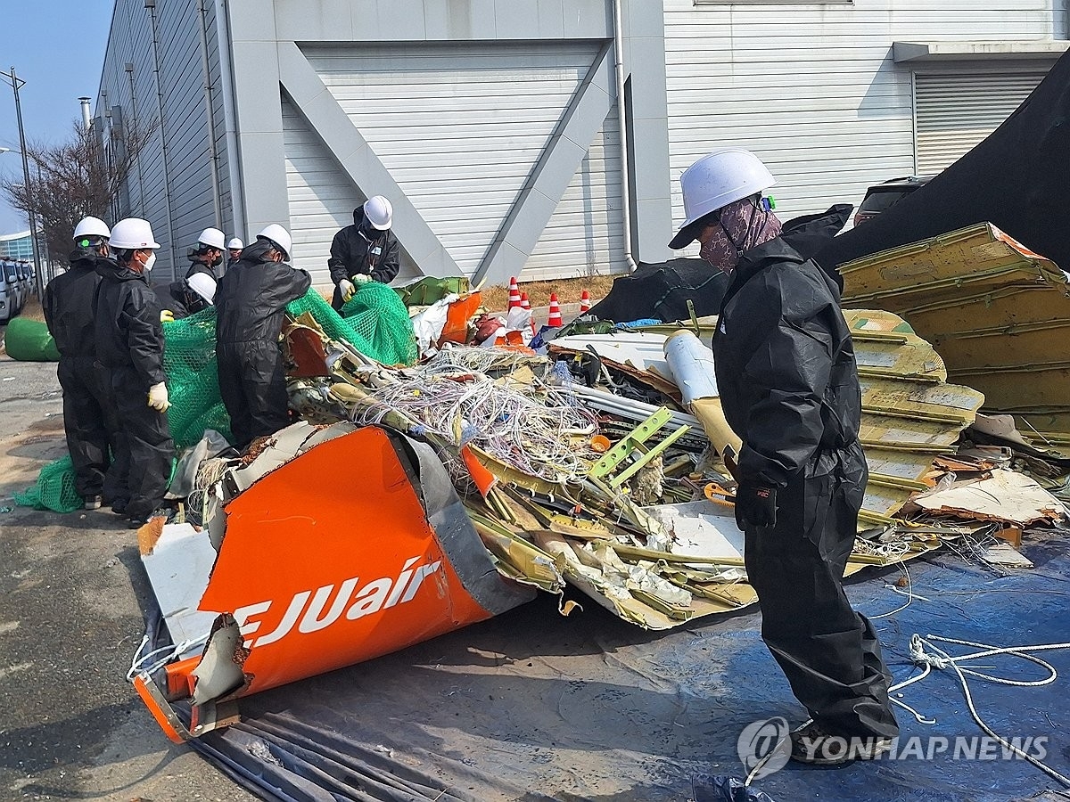 12일 국토교통부와 항공철도사고조사위원회, 전남경찰청 과학수사대 관계자들이 무안국제공항 공항소방대 뒤편에 보관된 여객기 잔해를 조사하고 있다. 연합뉴스.