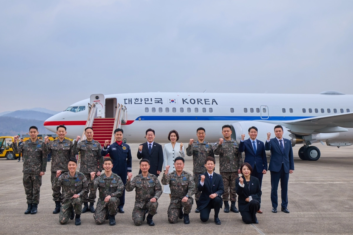 이재명 대통령과 김혜경 여사가 15일 경기 성남시 서울공항에서 신형 공군 2호기에 탑승하기 앞서 운영 요원 등과 기념 촬영을 하고 있다. 청와대 제공