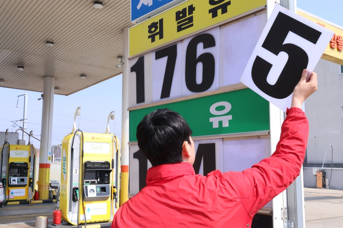 석유 최고가격제 시행 나흘째인 16일 충북 오송의 한 자영 알뜰주유소에서 직원이 휘발유, 경우 등 판매 제품의 가격을 낮춰 게시하고 있다. 연합뉴스