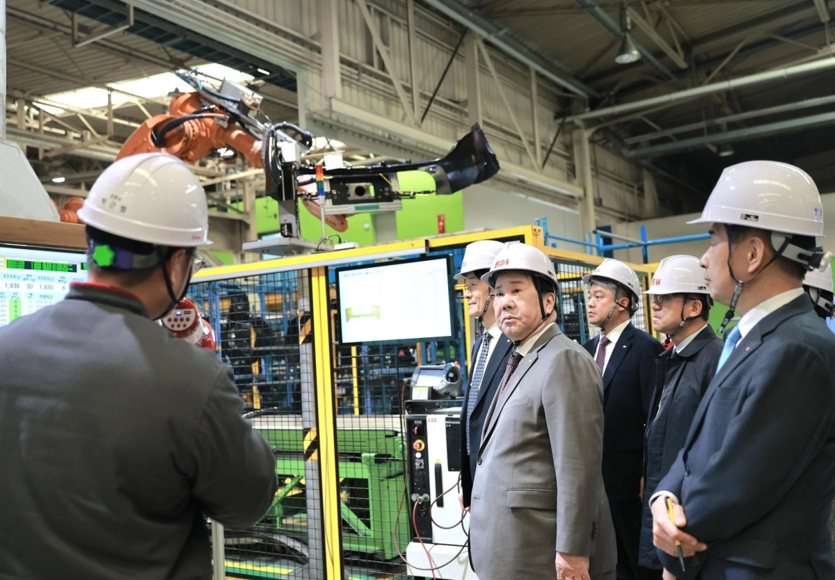 우오현(가운데) ﻿SM그룹 회장이 지난 16일 경북 구미시 남선알미늄 자동차사업부문의 자동차 부품 생산공장에서 로봇팔을 활용한 공정을 참관하며 운영 현황을 살피고 있다.     SM그룹 제공