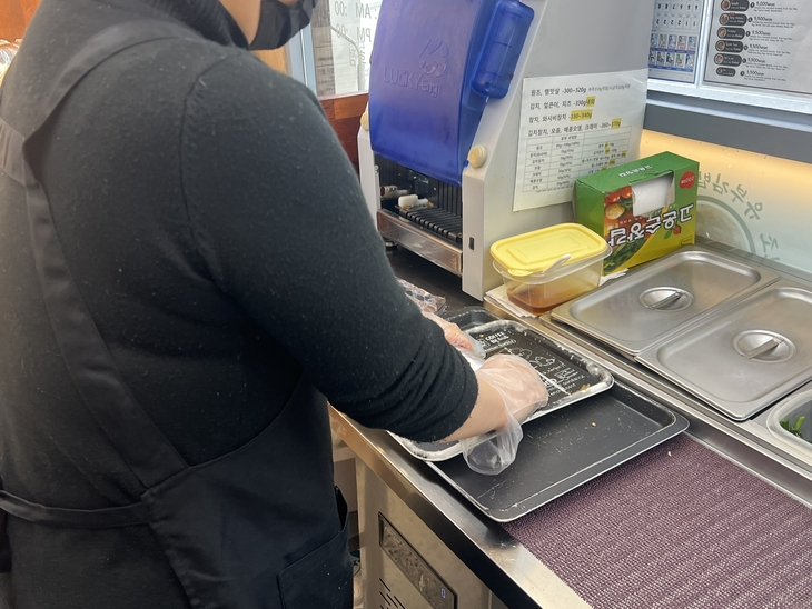 서울 광화문광장에서 김밥전문점을 운영하는 50대 임모씨가 18일 자신의 가게에서 ‘원조김밥’을 말고 있다. 임씨는 BTS가 광화문에서 대규모 공연을 여는 오는 21일 외국인 관광객들을 위해 돼지고기나 향신채소가 들어가지 않는 원조김밥만 만들어 팔 계획이다. 정회하 수습기자