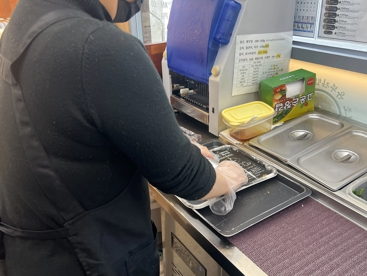 서울 광화문광장에서 김밥전문점을 운영하는 50대 임모씨가 18일 자신의 가게에서 ‘원조김밥’을 말고 있다. 임씨는 BTS가 광화문에서 대규모 공연을 여는 오는 21일 외국인 관광객들을 위해 돼지고기나 향신채소가 들어가지 않는 원조김밥만 만들어 팔 계획이다. 정회하 수습기자