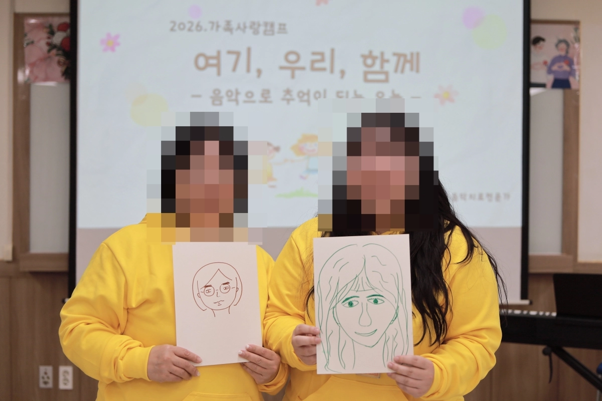 수도권의 한 교도소에서 18일 열린 ‘가족사랑캠프’ 행사에서 수용자와 가족이 직접 그린 그림을 들고 기념촬영을 하고 있다. 법무부 제공