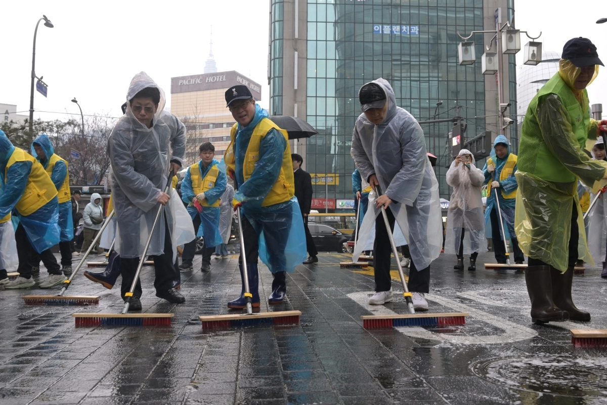 김길성(왼쪽 두번째) 중구청장이 지역 주민들과 함께 명동 거리를 물청소 하고 있다. 중구 제공