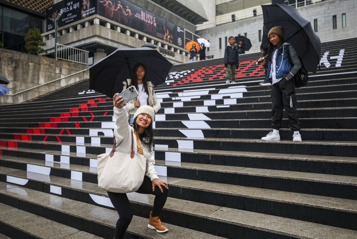 방탄소년단(BTS)의 광화문광장 컴백 공연을 앞두고 서울 도심이 ‘아미’ 등 전 세계 팬들의 열기로 뜨겁다. 외국인 팬들이 서울 종로구 세종문화회관 래핑 앞에서 사진을 찍고 있다. 뉴시스