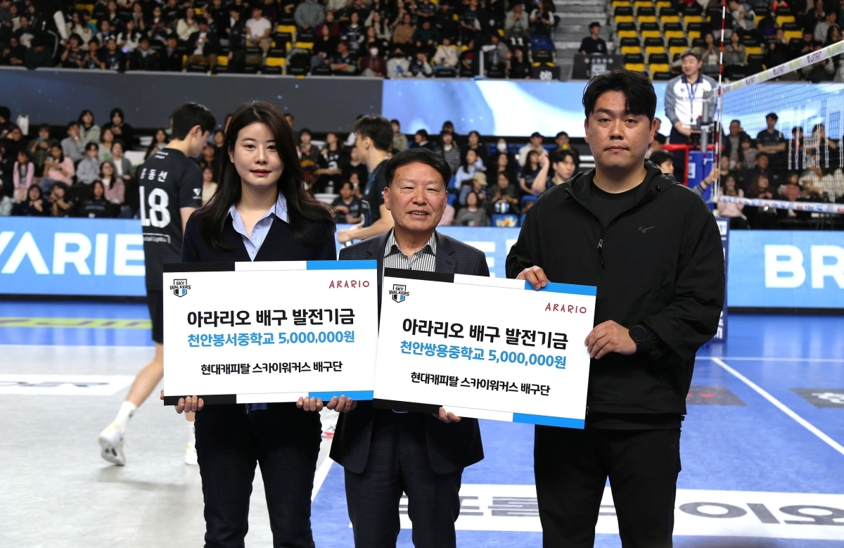 아라리오 김문수 대표이사(가운데)가 19일 현대캐피탈 스카이워커스 배구단 홈경기에 앞서 배구 꿈나무 지원을 위한 발전기금을 전달하고 있다. 아라리오 제공