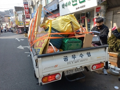 서울 구로구 개봉중앙골목시장에서 구로구 관계자들이 노점 적치물을 수거하고 있다.   구로구 제공