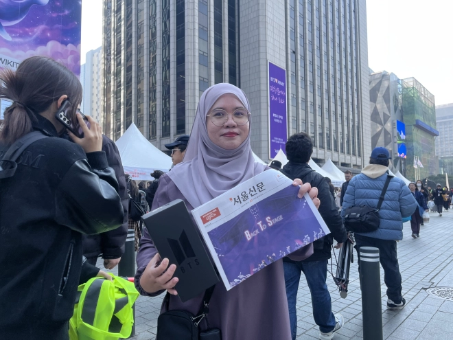 브루나이에서 온 무슬림인 나지아가 이슬람 전통 의상인 ‘아바야’를 보라색으로 맞춰 입고 21일 서울 종로구 광화문광장을 찾았다. 그의 손엔 그룹 방탄소년단(BTS)의 상징색인 보라색을 강조한 서울신문 BTS 특별판이 들려 있다. 박다운 수습기자