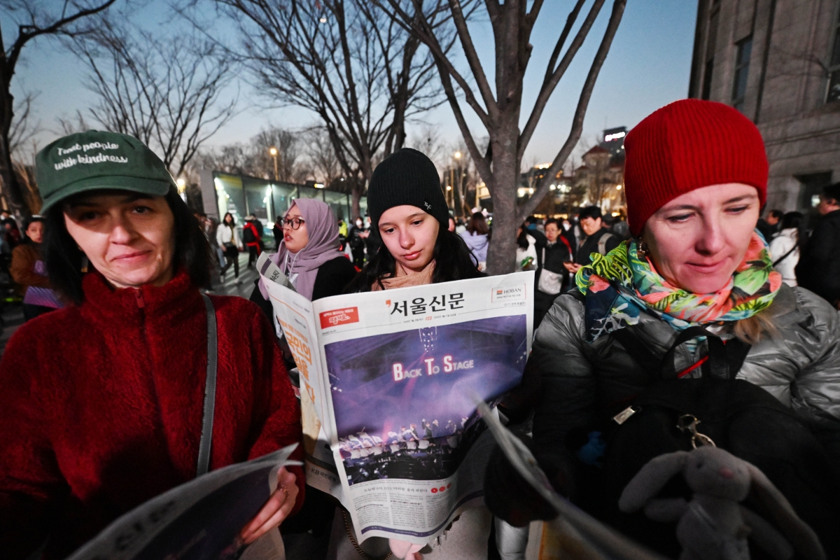 방탄소년단(BTS) 컴백 공연일인 21일 서울시청 광장에서 외국인 팬들이 호외로 제작된 서울신문 BTS 특별판을 살펴보고 있다. 2026.3.21 홍윤기 기자