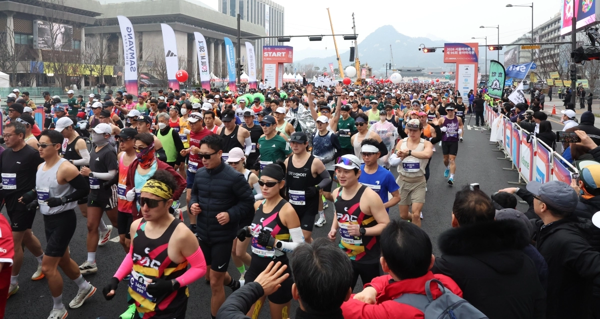 2026 서울마라톤 참가자들이 지난 15일 서울 광화문광장에서 출발 신호에 맞춰 쏟아져 나오고 있다. 올해 대회에선 일부 주자의 무리한 진로 변경과 응원단의 주로 침범 등이 논란을 일으켰다. 뉴스1