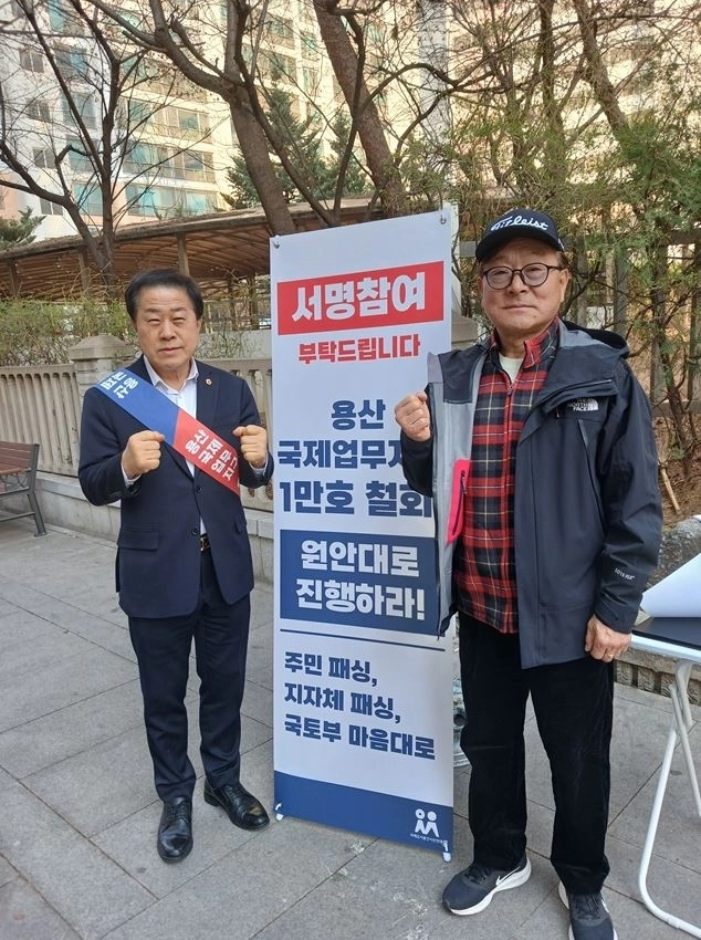 지난 22일 용산역과 이촌역 일대에서 진행된 ‘용산국제업무지구 1만호 주택건립 관련 제2차 주민 서명운동’ 현장에 참여한 김용호 서울시의원(왼쪽)이 용산구민과 함께 기념촬영을 하고 있다.