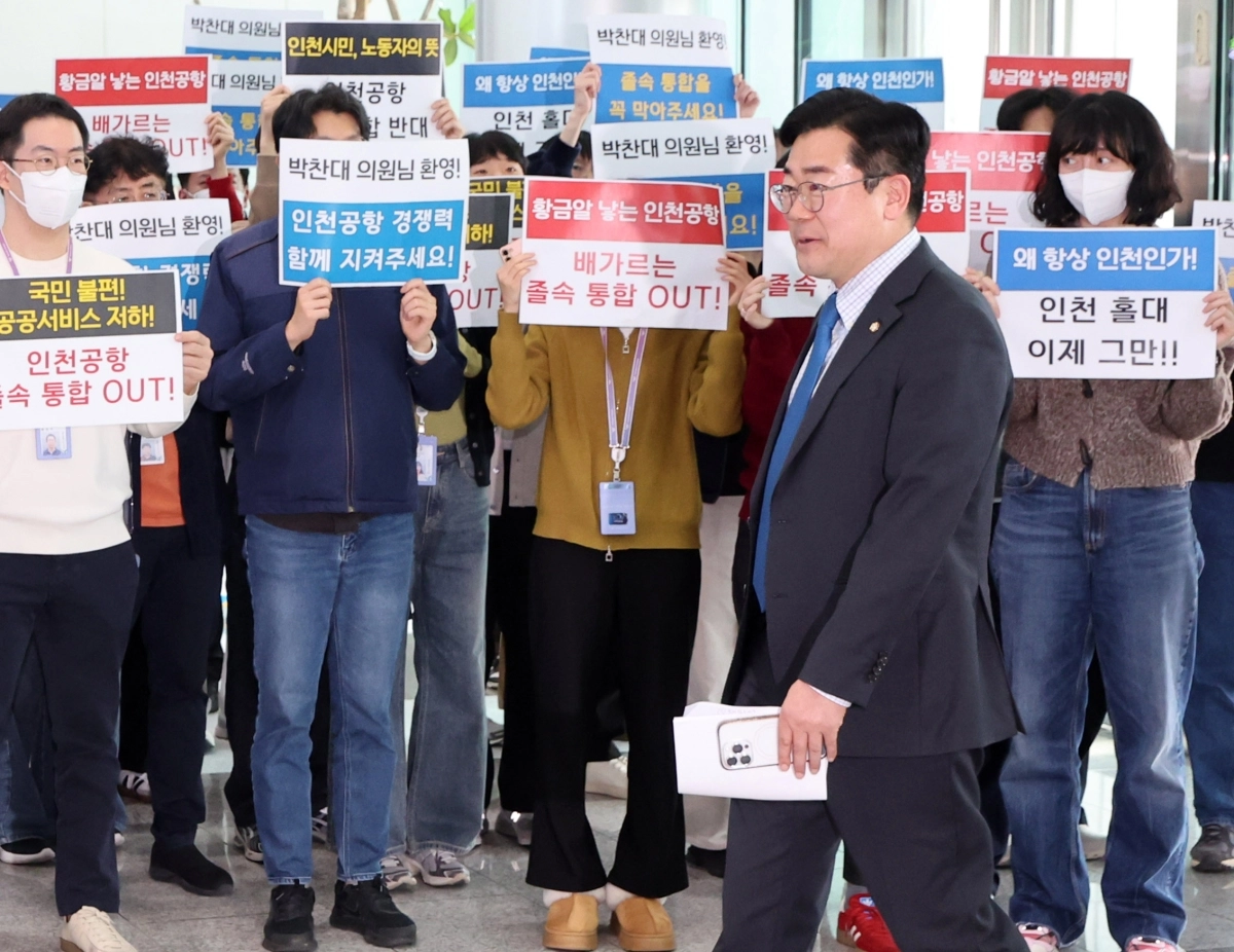 박찬대 더불어민주당 의원이 24일 인천공항공사에서 열린 간담회에 반대 피켓팅을 하고 있는 조합원들과 인사하며 들어가고 있다. 뉴시스
