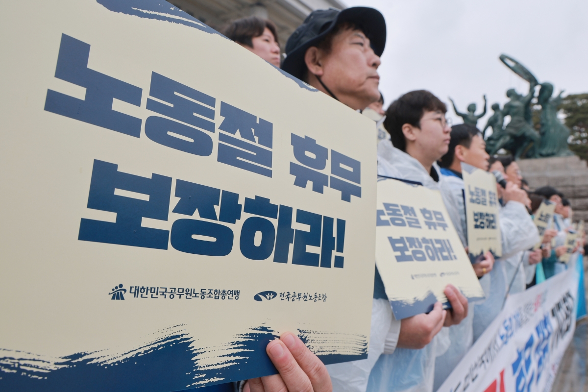 18일 국회 본청 앞 계단에서 전국공무원노동조합과 대한민국공무원노동조합총연맹이 연 공무원 노동절 휴무 쟁취 기자회견에서 참석자들이 손팻말을 들고 있다. 2026.3.18 연합뉴스