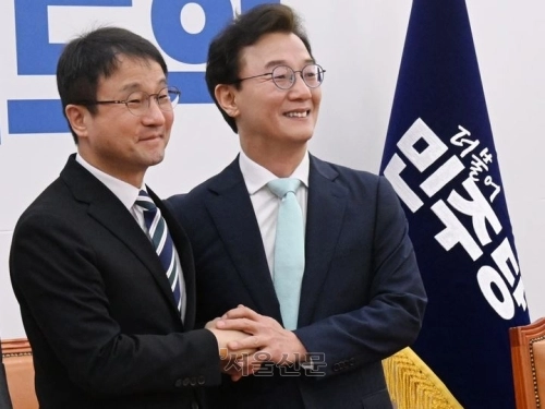 한병도(왼쪽) 더불어민주당 원내대표와 전재수 민주당 부산시장 예비후보가 24일 국회에서 열린 ‘부산 현안 관련 간담회’에서 손을 맞잡은 채 기념촬영을 하고 있다.  안주영 전문기자